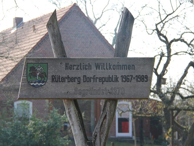  Holzschild auf dem "Herzlich Willkommen Rüterberg Dorfrepublik" steht