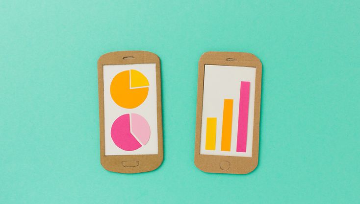 Zwei Mobiltelefone aus Pappe mit bunkten Konjunktursymbolen