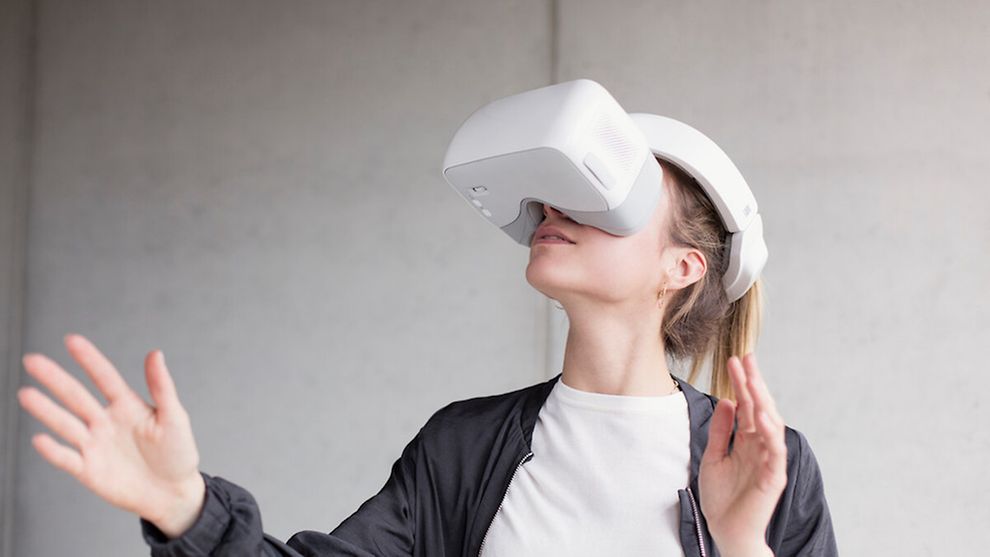 Eine Frau hat eine VR-Brille auf, die das halbe Gesicht bedeckt.
