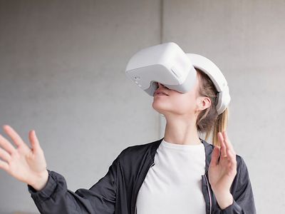  Eine Frau hat eine VR-Brille auf, die das halbe Gesicht bedeckt.