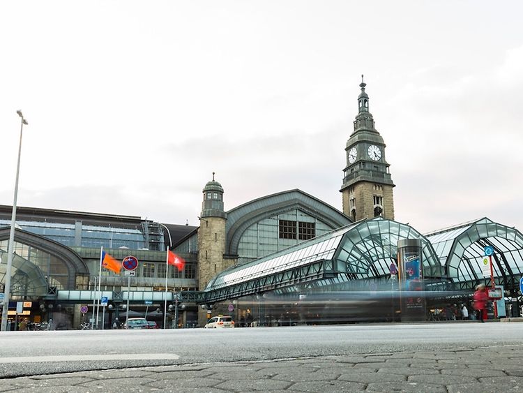  Der Hamburger Hauptbahnhof wird von außen gezeigt. Man sieht ein großes Gebäude.