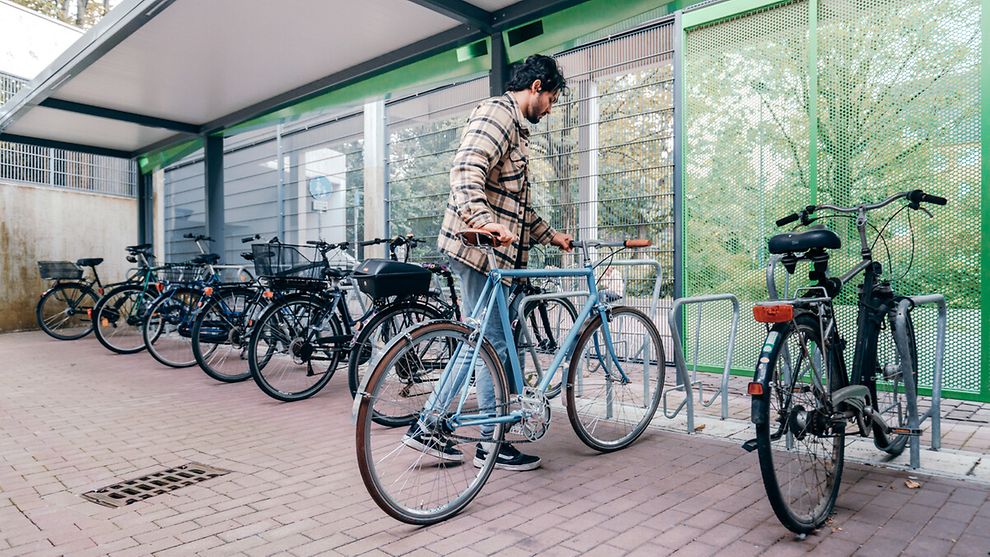 Mann mit Rad am Fahrradstellplatz am Bahnhof Neumünster