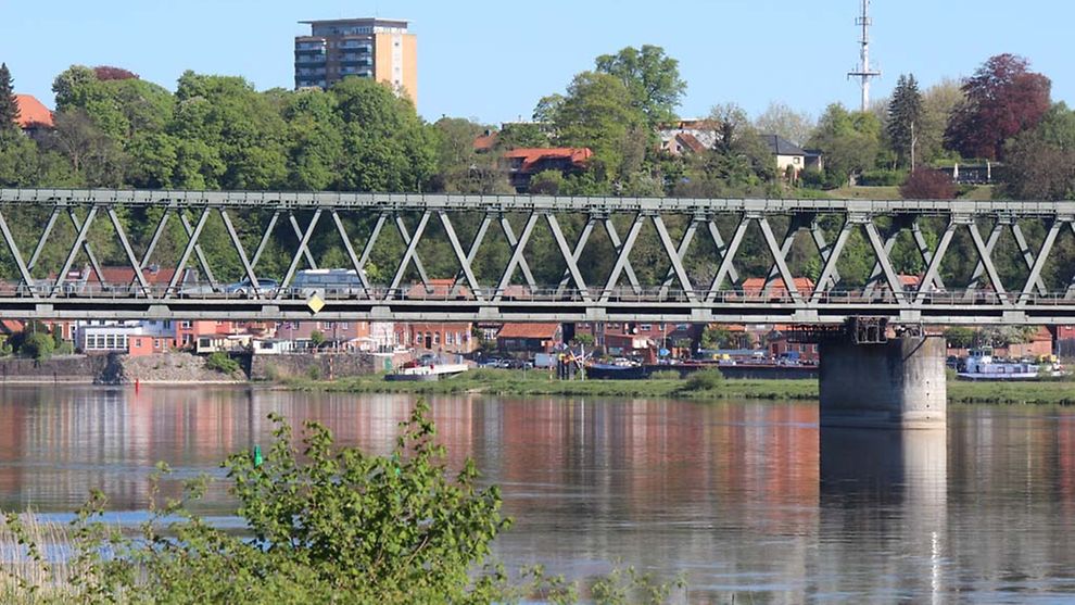 Eine Brücke überspannt die Elbe in Lauenburg. Im Hintergrund sind Häuser zu sehen.