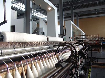 In Einer Maschine sind Wollfäden einspannt. Es ist eine Maschine im Museum Tuch + Technik in Neumünster.