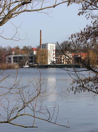 Am anderen Ende eines Gewässers ist eine Fabrikanlage zu sehen. Es ist die ehemalige Brauerei Schall & Schwencke.