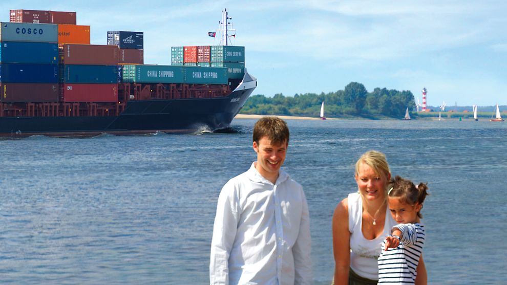 Familienausflug an die Elbe, im Hintergrund: Containerschiff, Windräder Segelboote und ein Leuchtturm